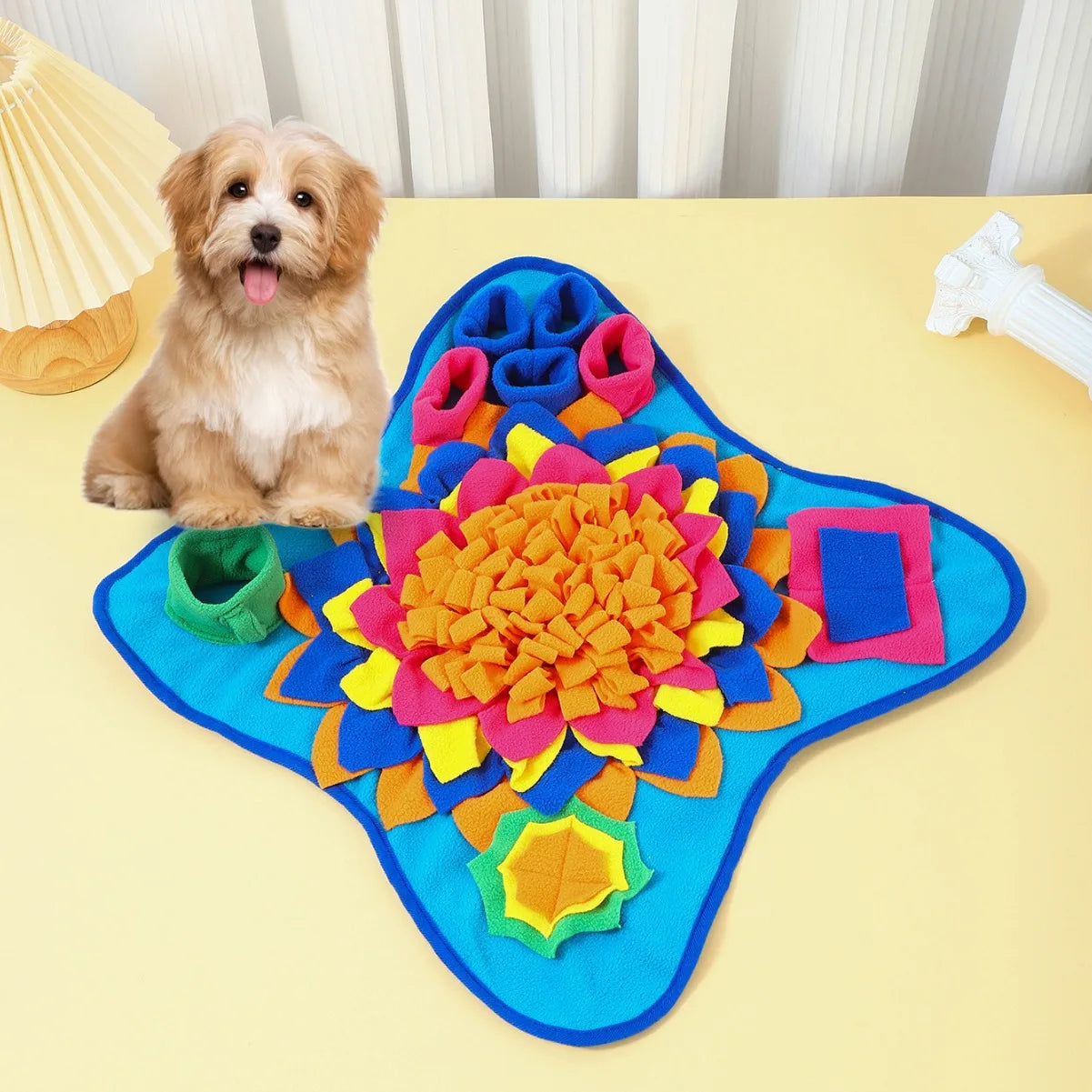 Dog sitting next to a colorful dog mat on a yellow surface.